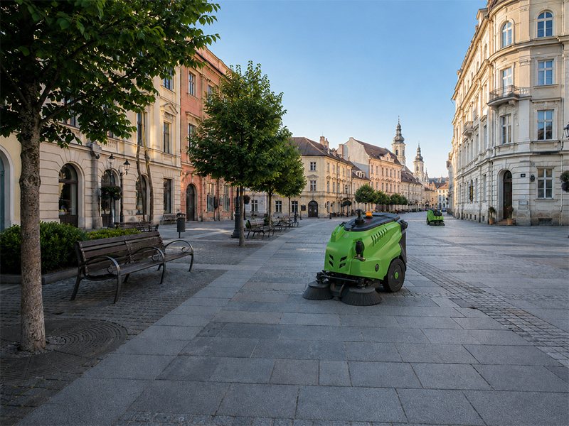 Măturătoare compactă curățând pavajul unei zone pietonale din centrul istoric