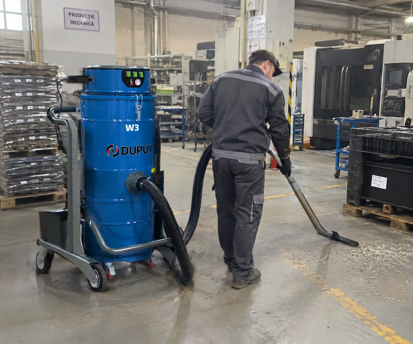 Operator care aspiră reziduurile din hala de producție cu Dupuy W3