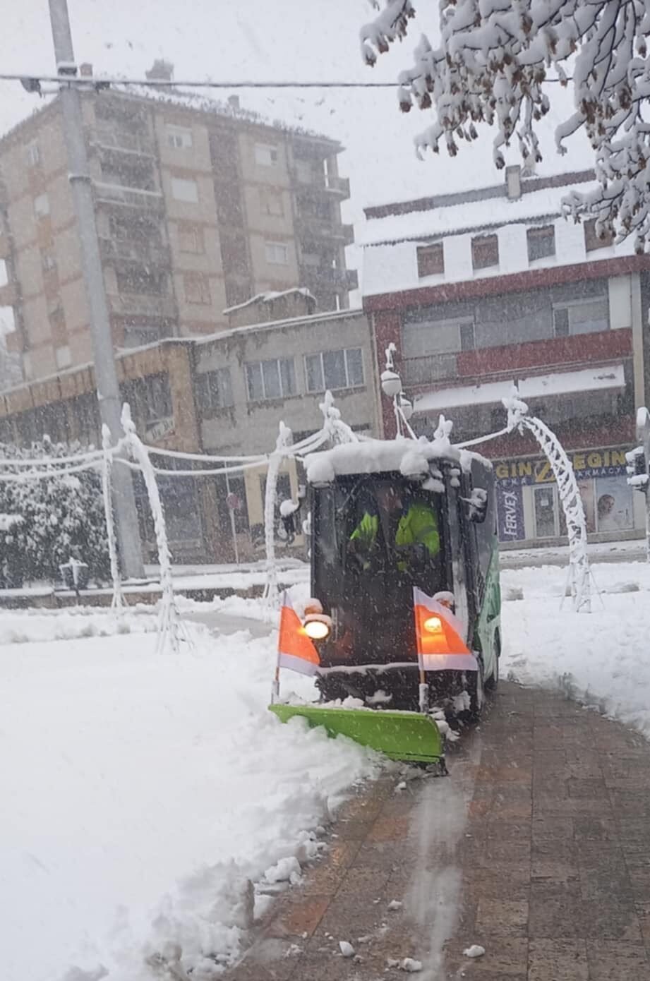 Green Machines 636 cu lama de zăpadă montată, curățând un trotuar înzăpezit